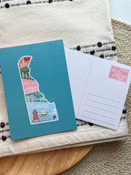 A postcard with an illustration of Delaware state in a colorful artistic style on a teal background.
