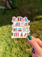 Sticker of a bookshelf with books and 'Read More Books' text held by a hand against a grassy background