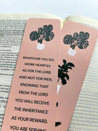 front and back rectangular bookmarks with rounded corners, featuring a green plant illustration and a Colossians 3:23-24 Bible verse, placed on a patterned fabric surface.