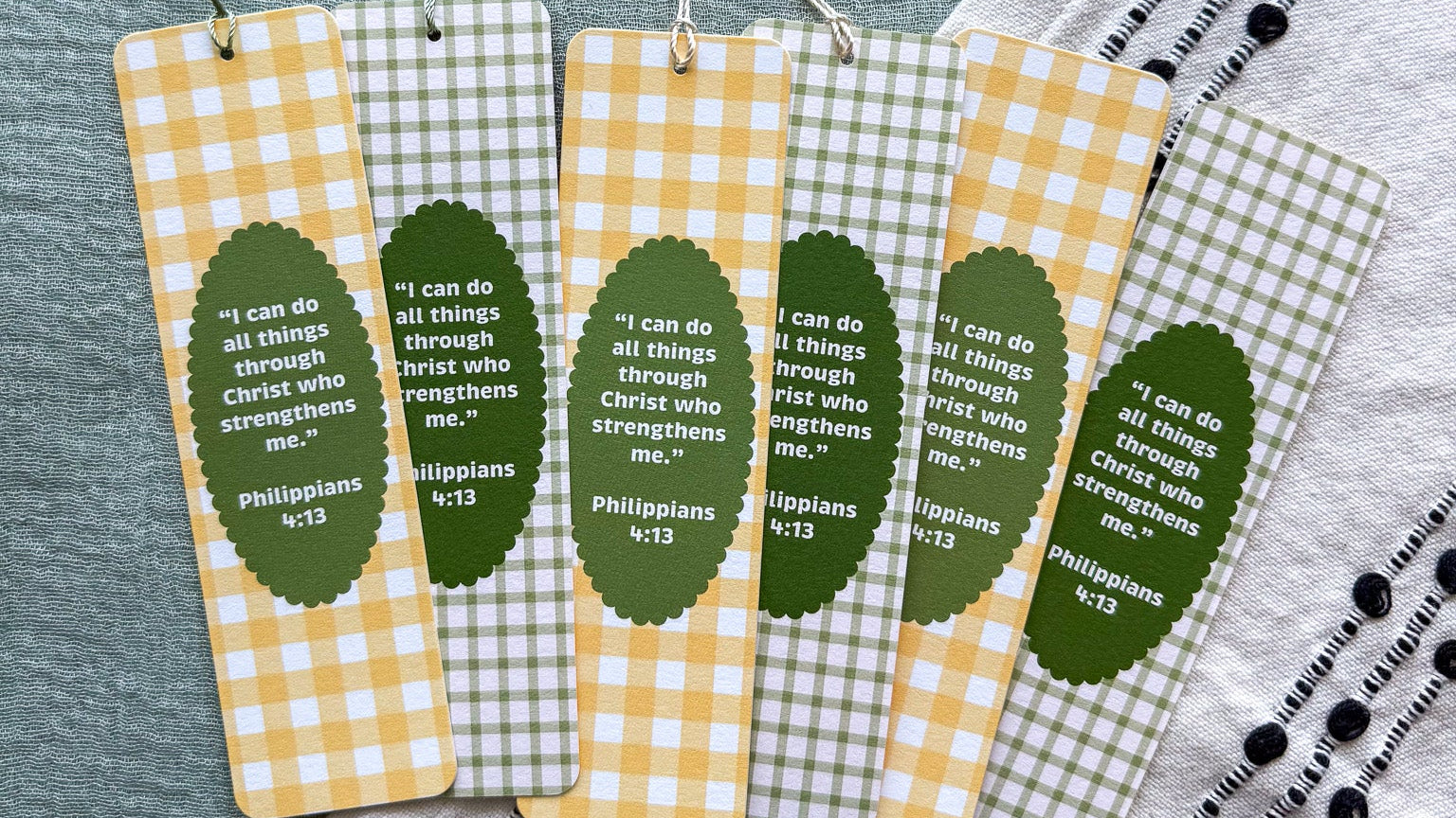 Set of four checkered bookmarks with tassels on a textured surface