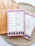 A notepad with plant illustrations at the bottom, a pink background with text areas for notes, weekly schedule. placed on a woven mat.