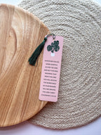 rectangular bookmarks with rounded corners, featuring a green plant illustration and a Colossians 3:23-24 Bible verse, placed on a patterned fabric surface.