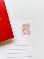 A postcard with an illustration of Virginia state landmarks on a red background with the word 'Virginia' written across the lower part of the state outline.