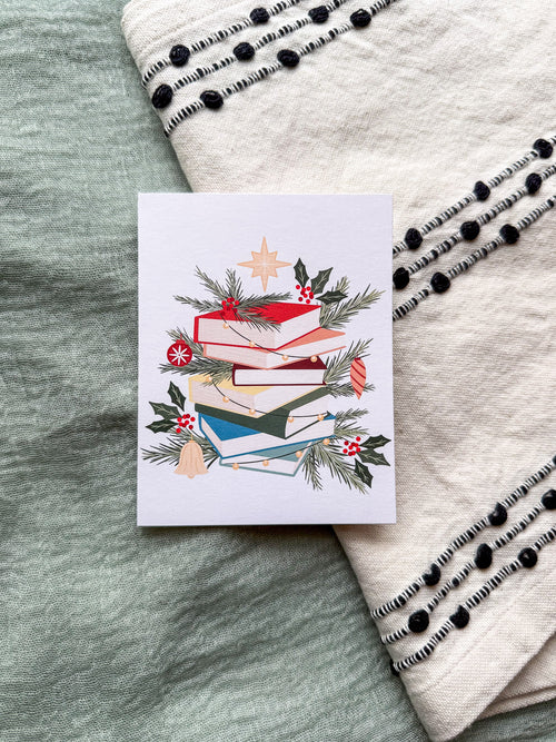 Greeting card with a Christmas book greenery design on a textured surface