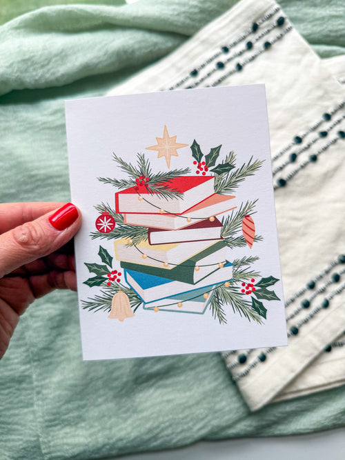 Greeting card with a Christmas book greenery design on a textured surface