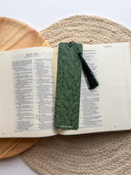 Two bookmarks with one having a green floral pattern and the other a beige grennery design, both with text on them, placed in a clear poly sleeve.