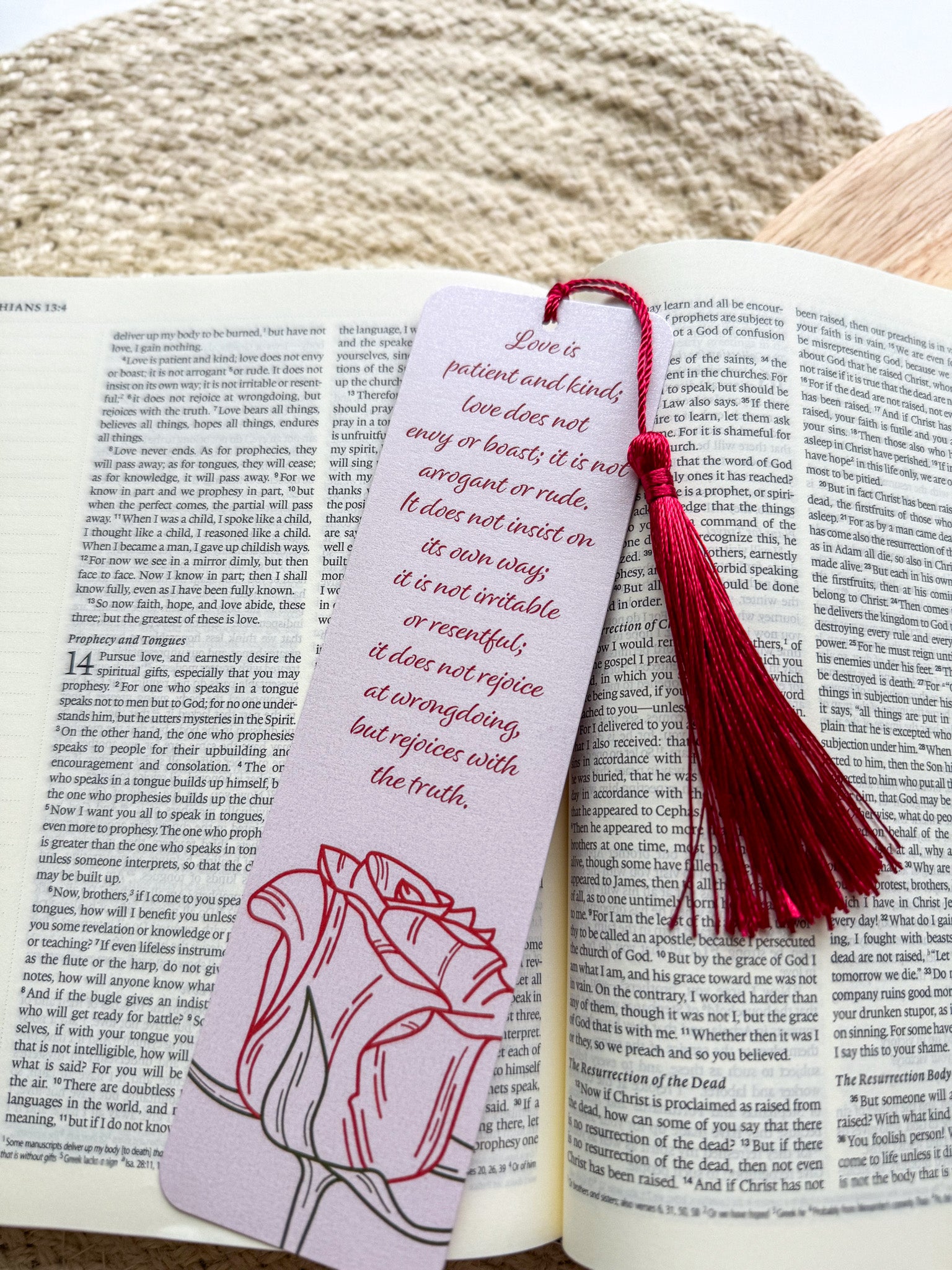 Bookmark with tassel on an open book, featuring a quote and illustration.