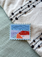 Colorful Colorado-themed stamp sticker on a texutre fabric surface 