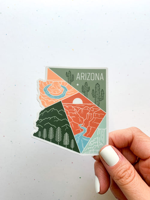 A sticker with a geometric design representing the state of Arizona, held against a backdrop of the Grand Canyon.