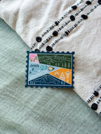 Colorful Washington-themed stamp sticker on a textured fabric surface 