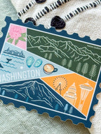 Colorful Washington-themed stamp sticker on a textured fabric surface 