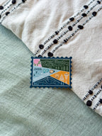 Colorful Washington-themed stamp sticker on a textured fabric surface 