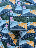 Colorful Washington-themed stamp sticker on a textured fabric surface 