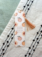 Bookmark with peach pattern and tassel on a textured surface