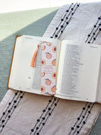 Open bible with a peach pattern bookmark on a textured fabric surface