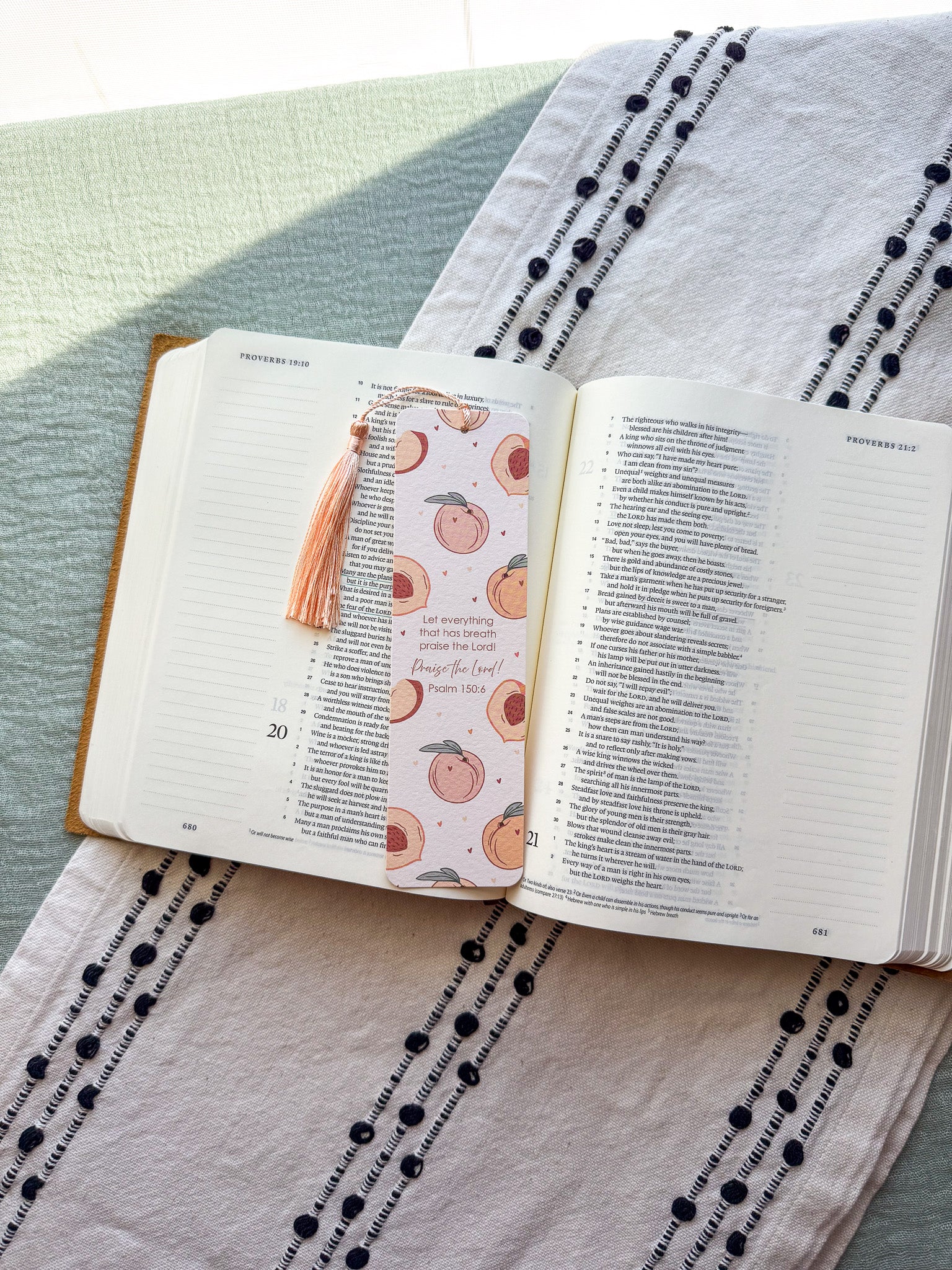 Open bible with a peach pattern bookmark on a textured fabric surface