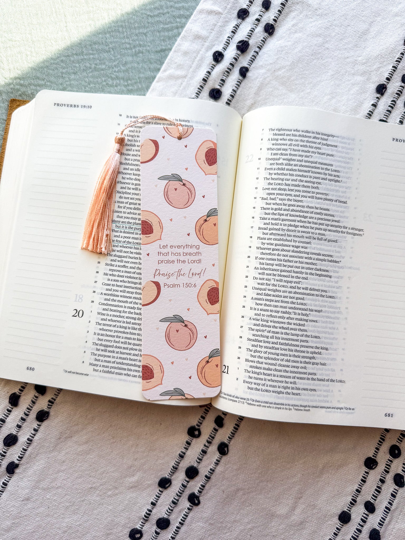 Open book with a decorative bookmark featuring peach illustrations on a textured fabric background.