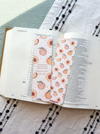 Open book with decorative bookmarks featuring peach patterns on a textured fabric background.