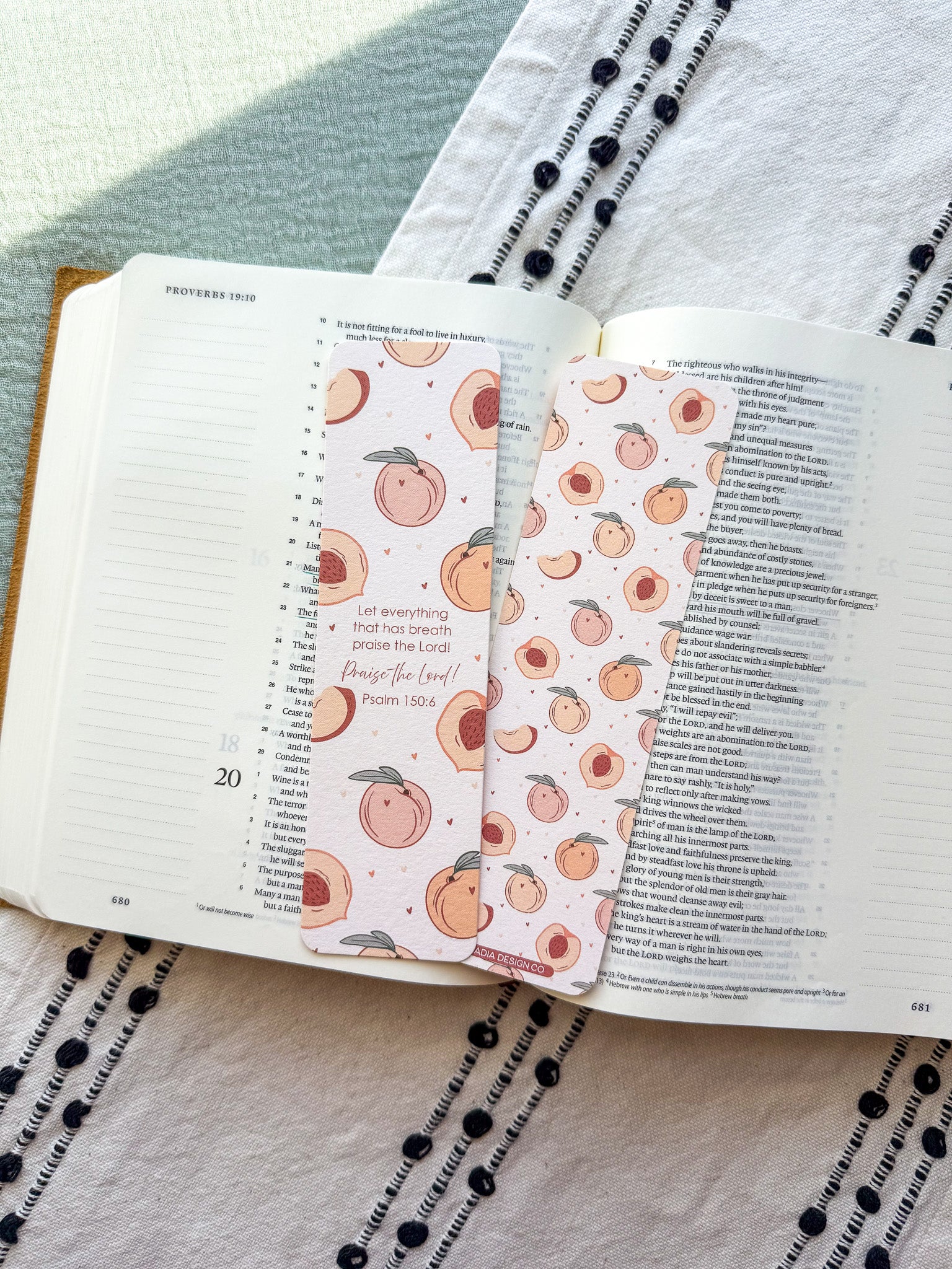 Open book with decorative bookmarks featuring peach patterns on a textured fabric background.