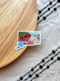 Colorful Connecticut outline design sticker with a scenic design on a textured surface on a wooden object and fabric.