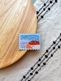 Colorful Colorado-themed stamp shaped magnet on a wooden surface 