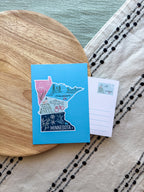 Colorful Minnesota-themed postcard on a textured surface