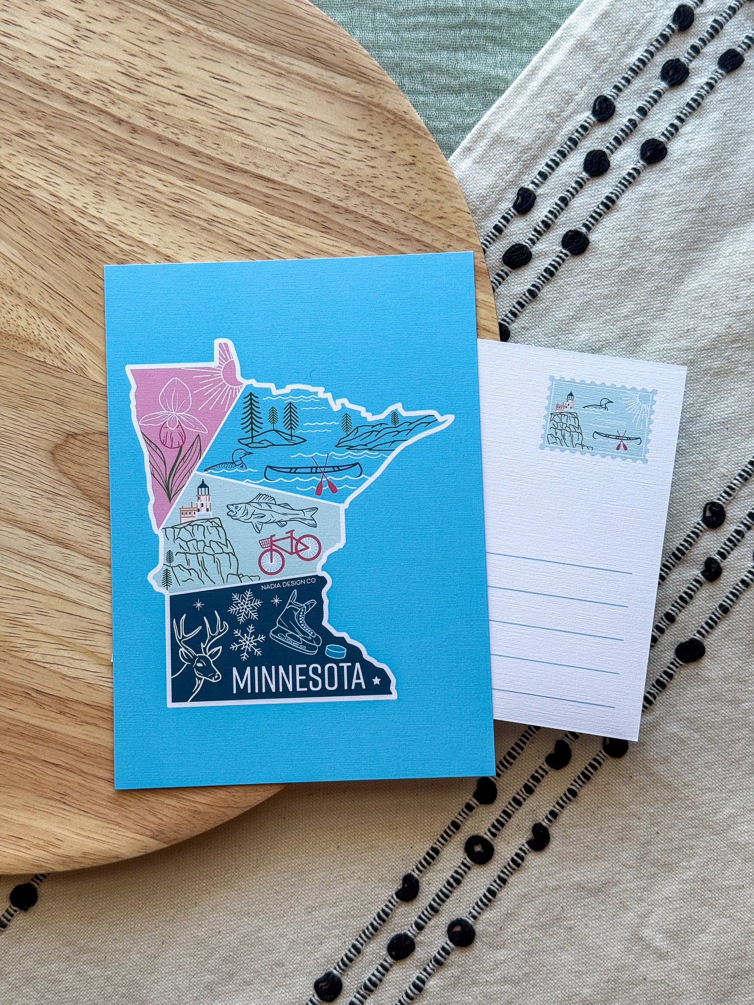 Colorful Minnesota-themed postcard on a textured surface