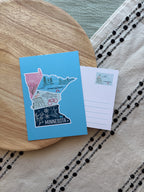 Colorful Minnesota-themed postcard on a textured surface