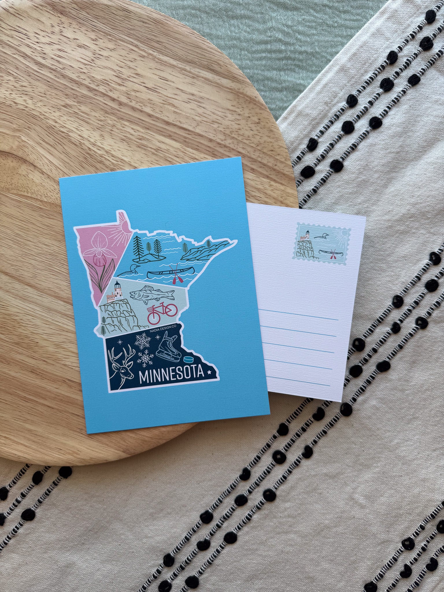 Colorful Minnesota-themed postcard on a textured surface