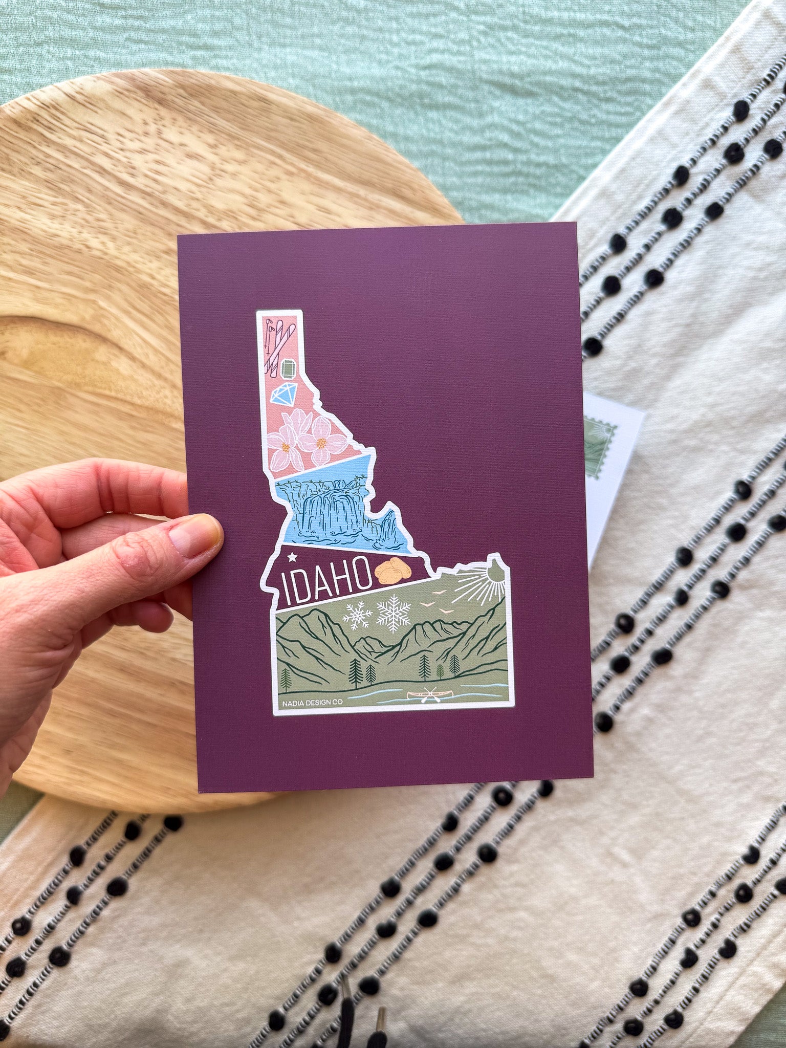 Colorful Idaho themed postcard on a textured surface