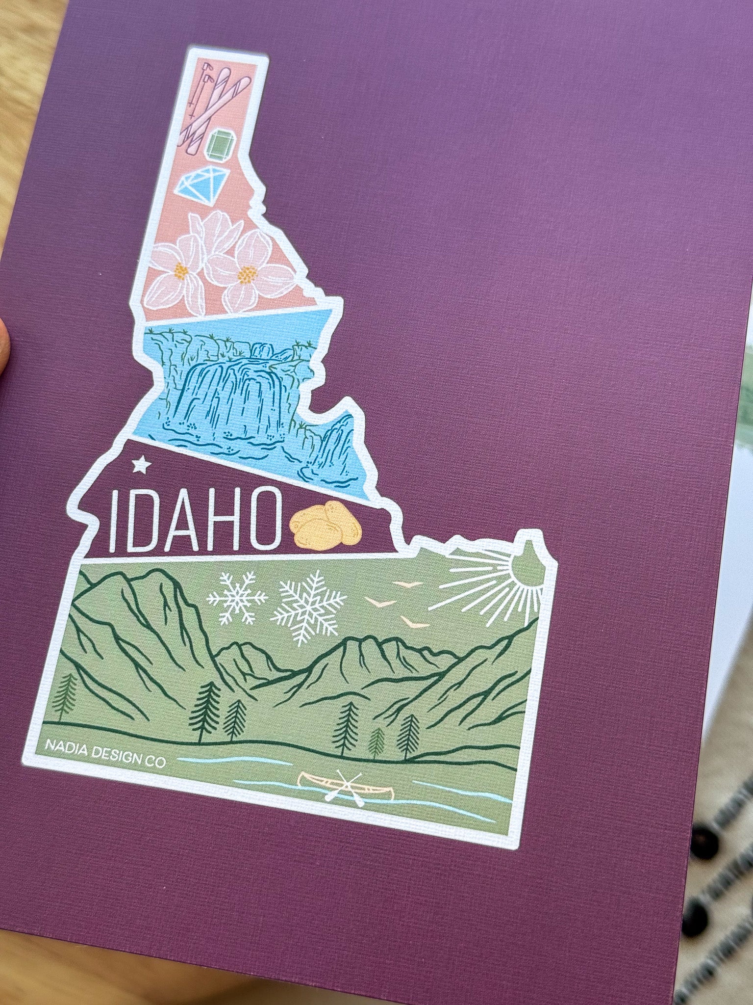 Colorful Idaho themed postcard on a textured surface