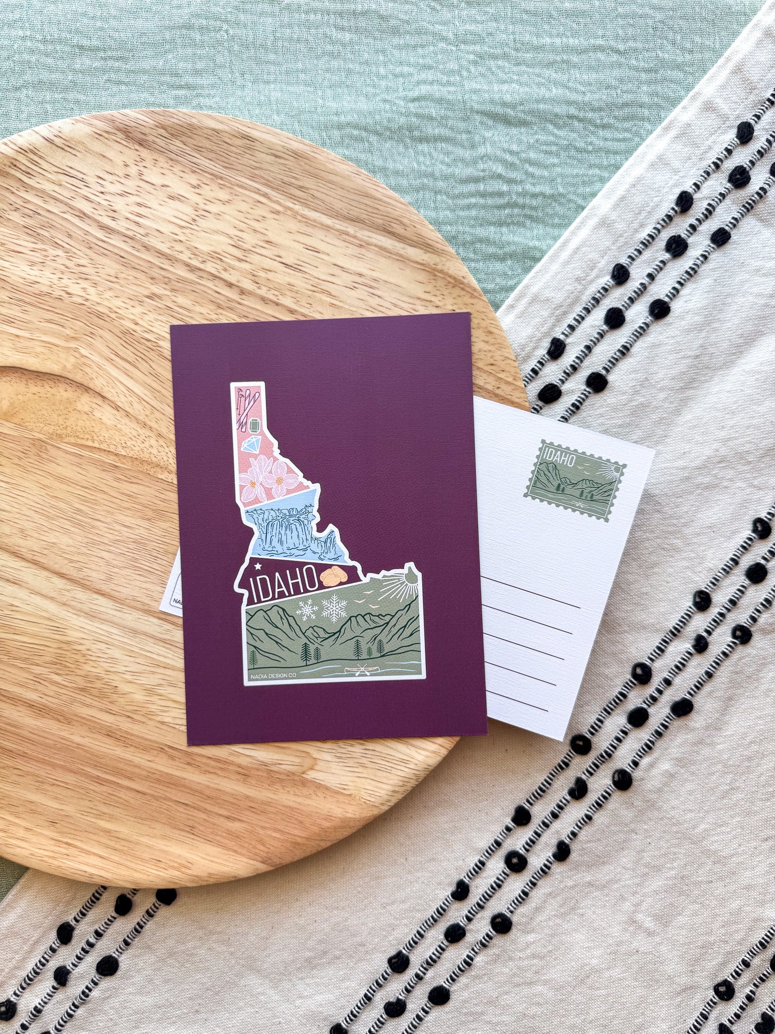 Colorful Idaho themed postcard on a textured surface