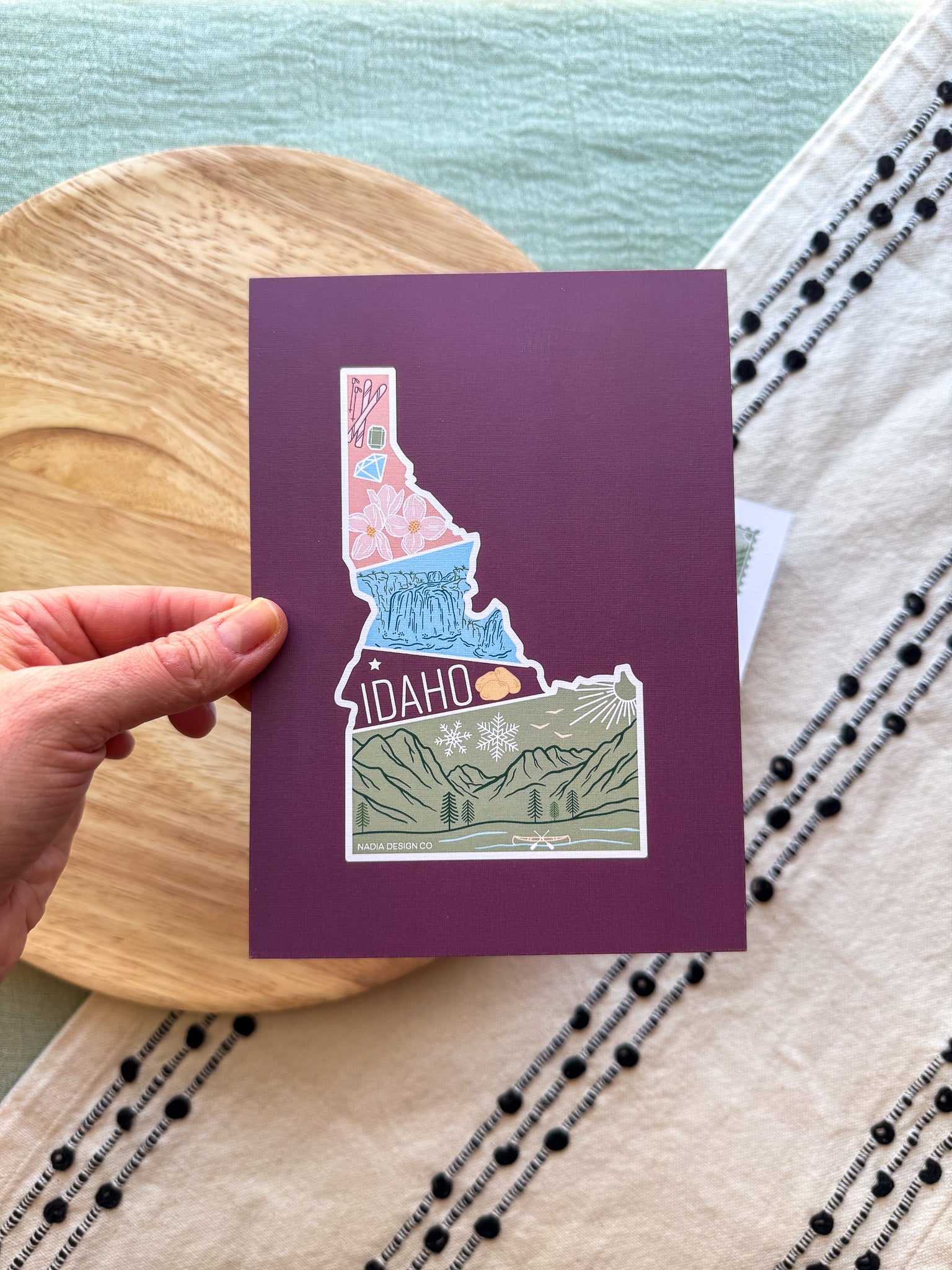 Colorful Idaho themed postcard on a textured surface