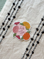 Floral sticker with motivational text on a textured surface with decorative elements