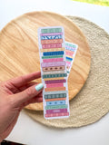 colorful pile of books illustrated bookmarks with quotes on the spin on a wooden background