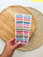 colorful pile of books illustrated bookmarks with quotes on the spin on a wooden background