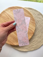 pink peony bookmark featuring floral designs on a woven surface.