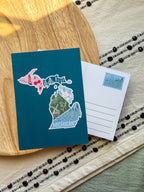 postcard with Michigan design on a wooden surface