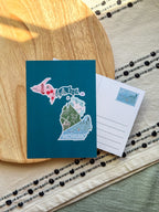 Postcard with a illustration about state of Michigan on a wooden surface