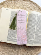 pink peony bookmark featuring floral designs and text "in Christ alone my hope is found" with green tassel on a woven surface.
