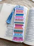 colorful pile of books illustrated bookmarks with quotes on the spine on a wooden background