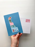 A postcard with an illustration of Delaware state in a colorful artistic style on a blue background.