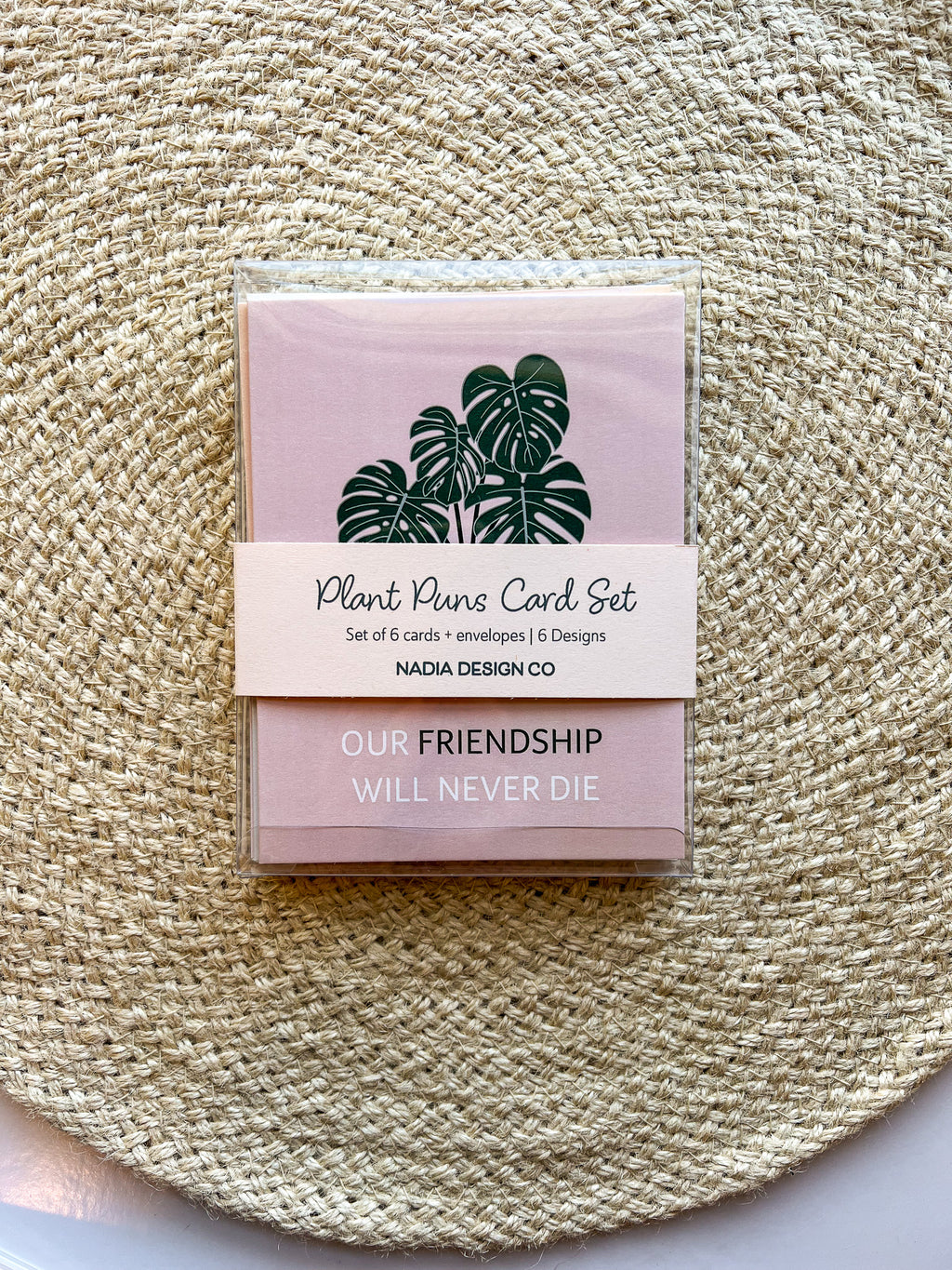 A set of six illustrated greeting cards with various houseplants and punny captions related to plants displayed on a textured surface.