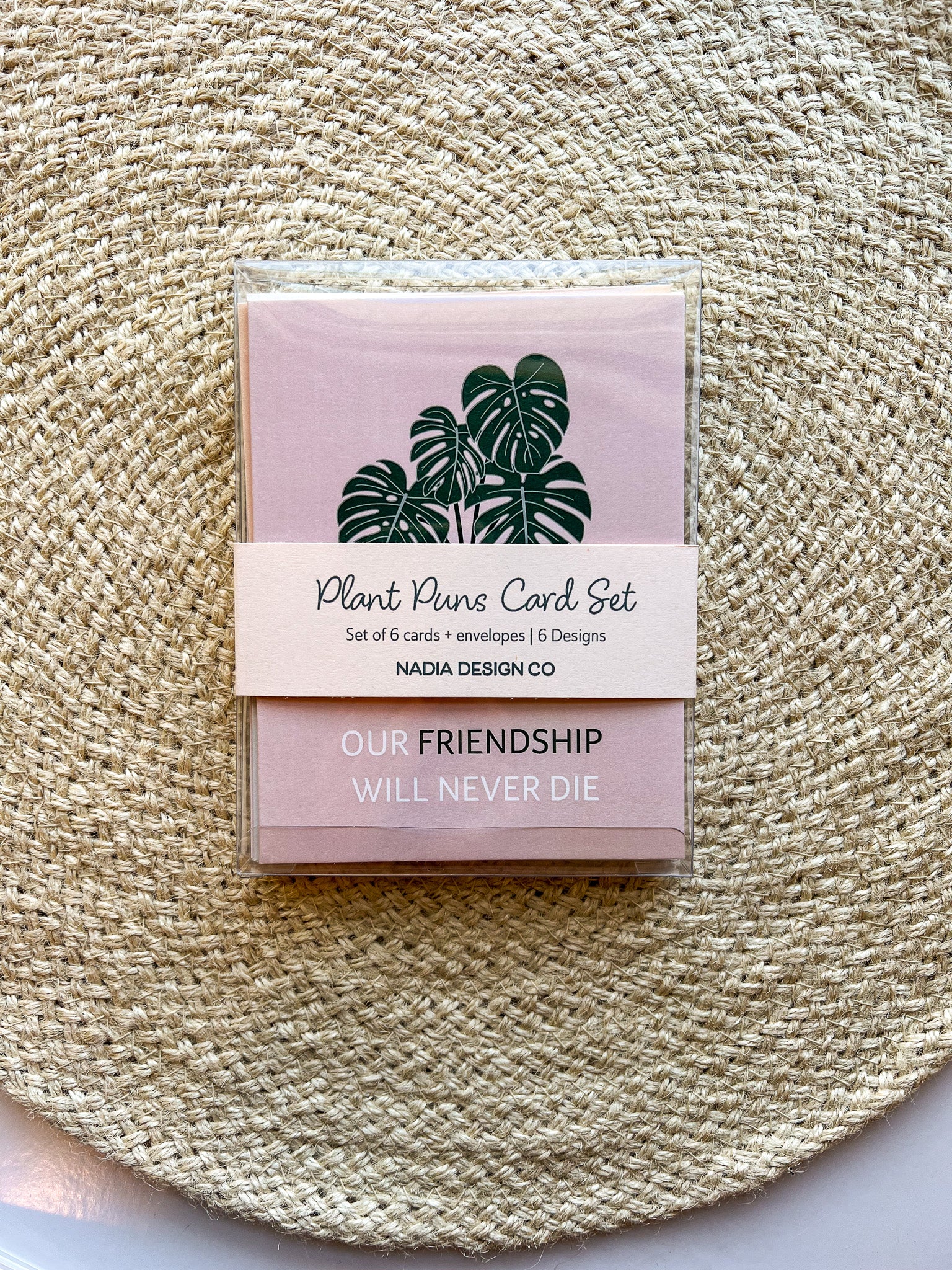 A set of six illustrated greeting cards with various houseplants and punny captions related to plants displayed on a textured surface.