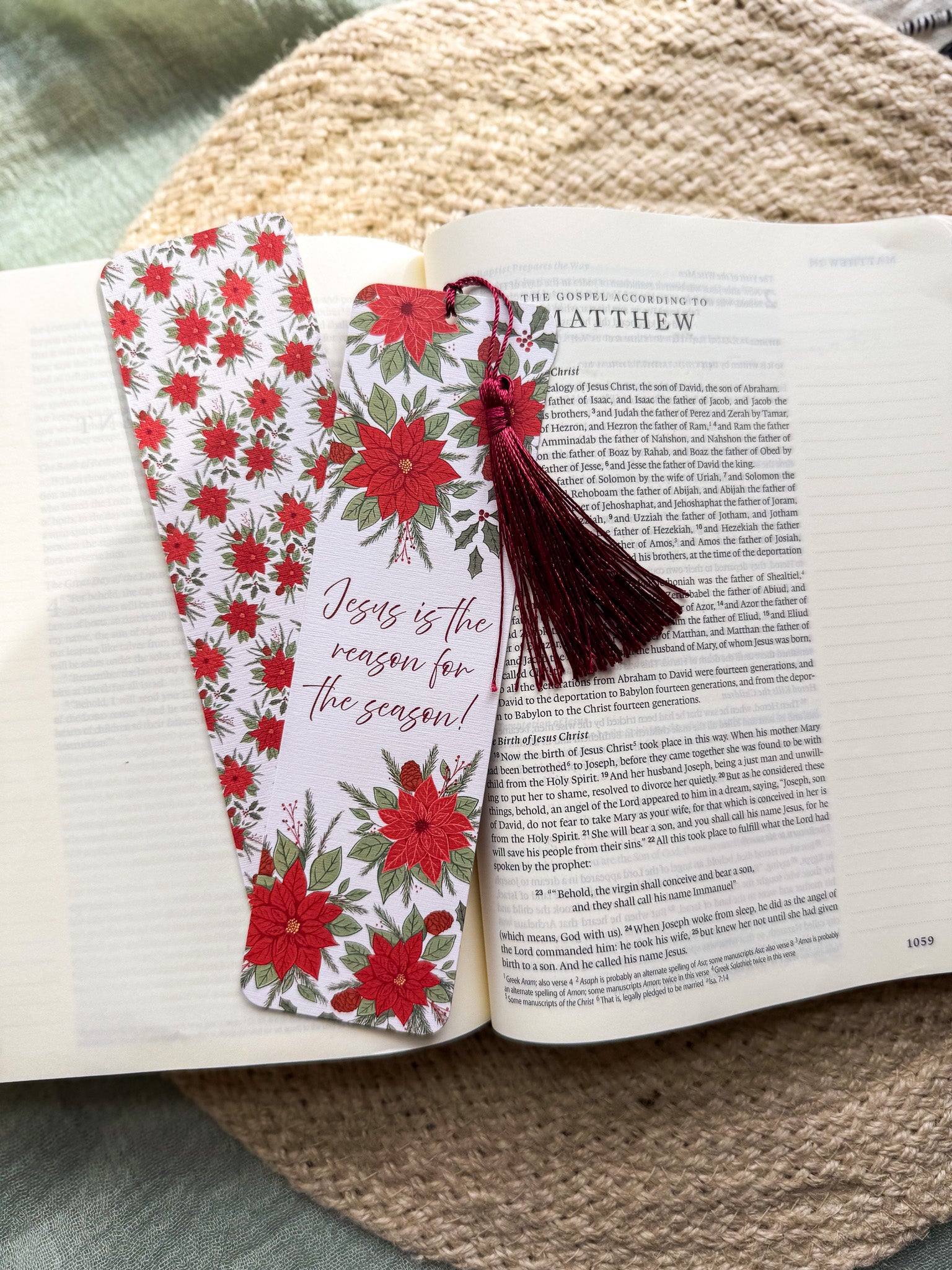 poinsettia Floral Christian bookmark with text "Jesus is the reason for the season" on a textured surface