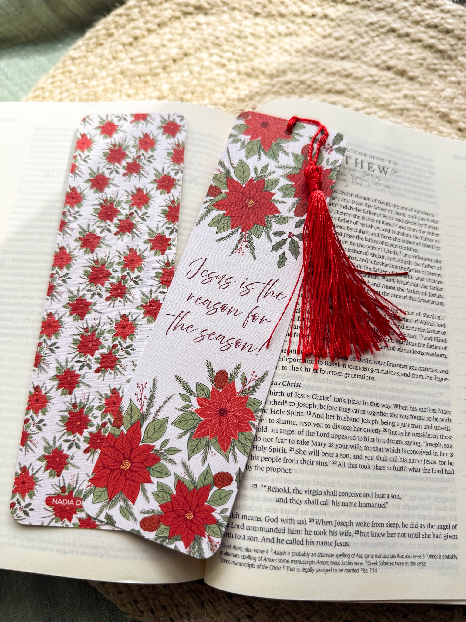 poinsettia Floral Christian bookmark with text" Jesus is the reason for the season" with red tassel on a textured surface