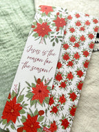 poinsettia Floral Christian bookmark with text" Jesus is the reason for the season" on a textured surface