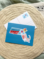 Postcard with a Massachusetts illustrated design on a textured surface