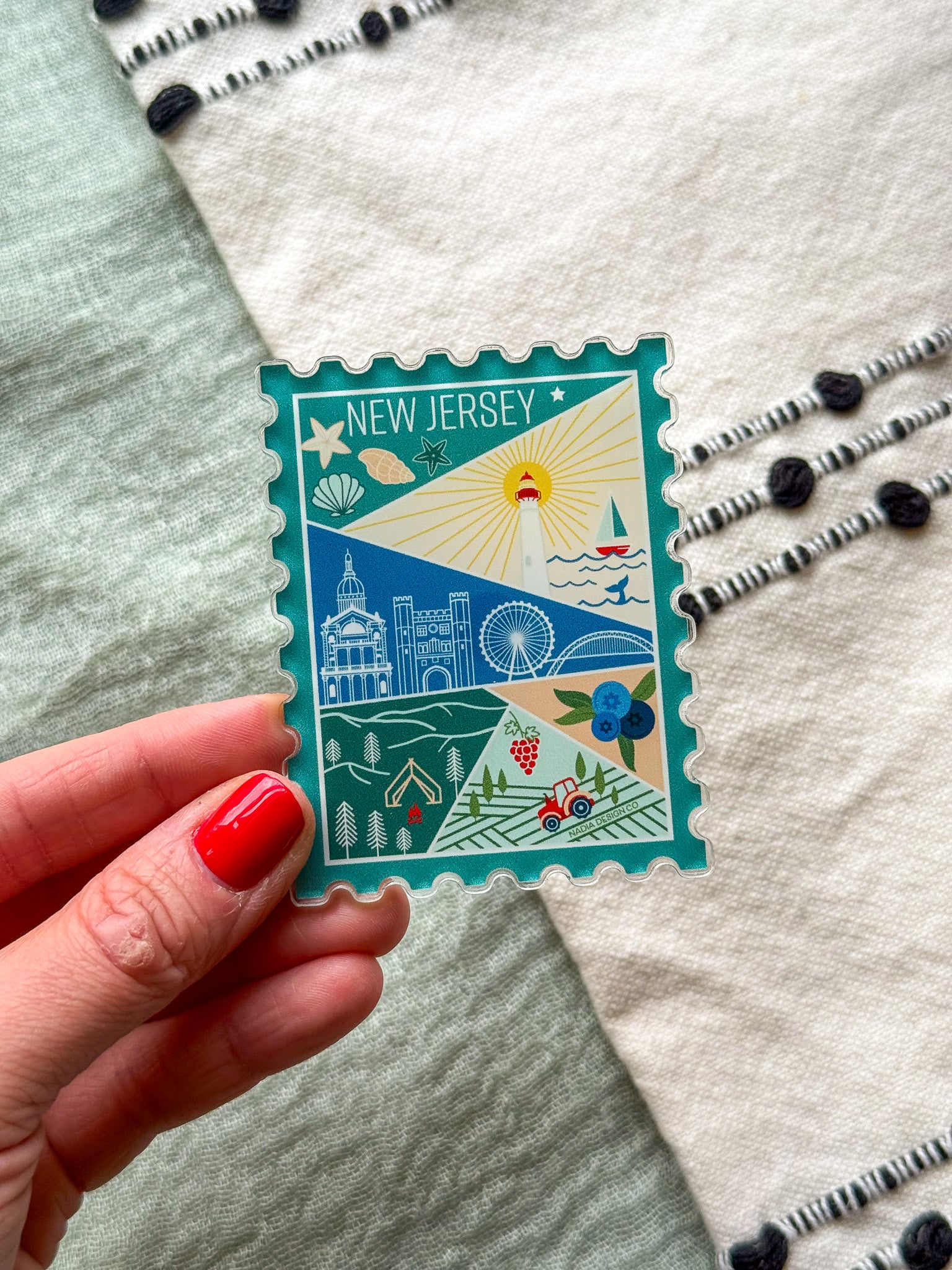illustrated New Jersey Acrylic Stamp Magnet held and textured fabric behind