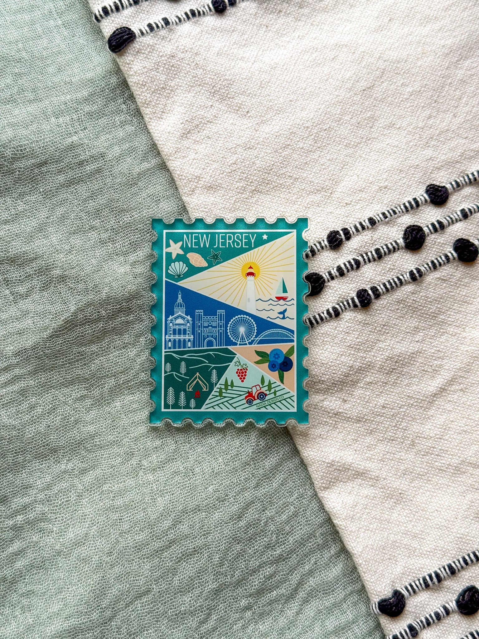 illustrated New Jersey Acrylic Stamp Magnet held and textured fabric behind
